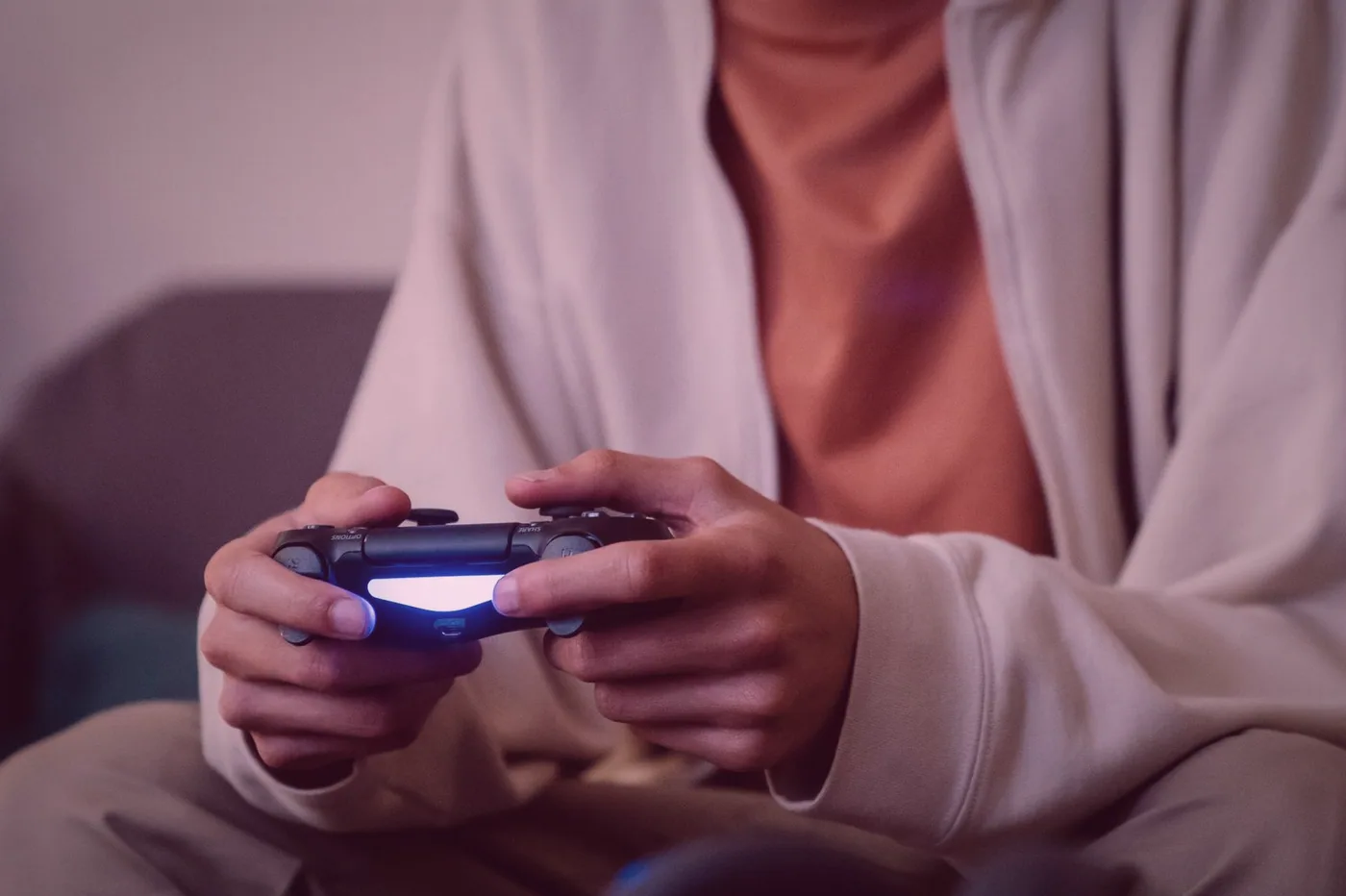 A row of players seated on a couch with controllers in hand